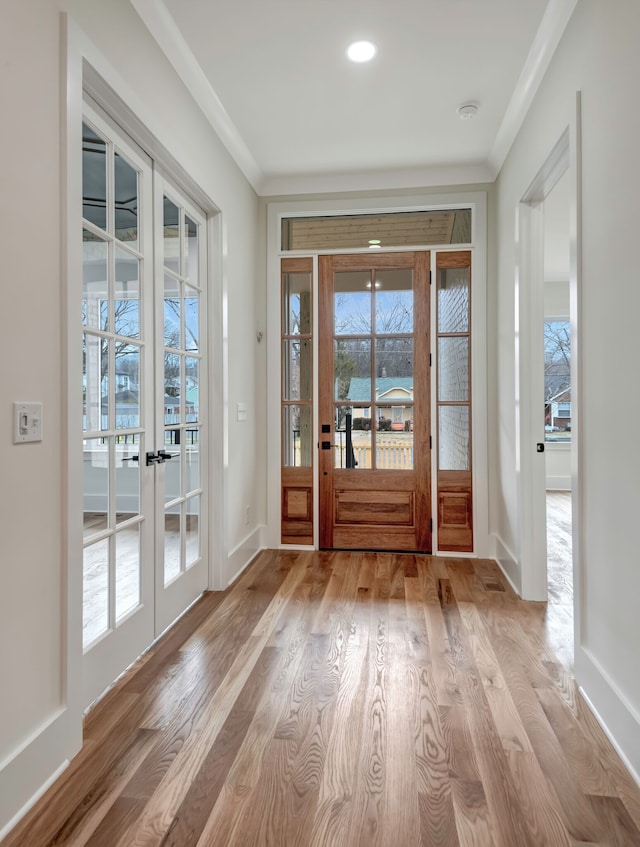 doorway to outside with french doors, ornamental molding, and light hardwood / wood-style floors