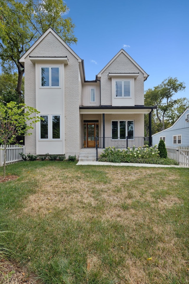 view of front of property with a porch and a front lawn