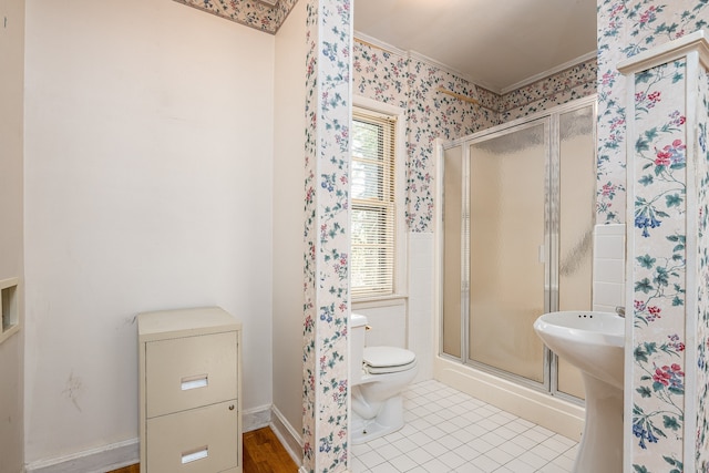 bathroom featuring ornamental molding, tile patterned floors, a shower with shower door, and toilet