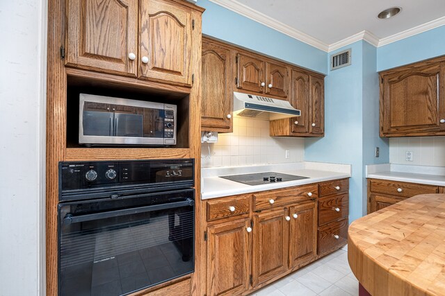 kitchen featuring light tile patterned floors, ornamental molding, decorative backsplash, and black appliances