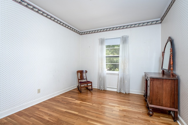 living area featuring light hardwood / wood-style floors and crown molding