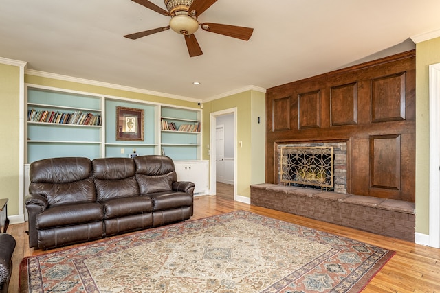 living room featuring crown molding, ceiling fan, light hardwood / wood-style flooring, and built in features