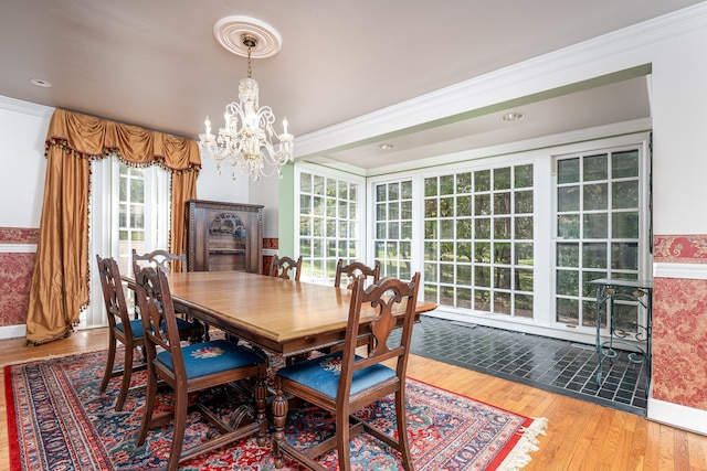 dining space featuring crown molding, an inviting chandelier, and hardwood / wood-style flooring