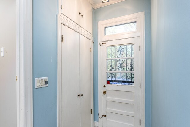 doorway to outside with ornamental molding