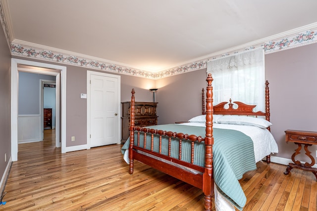 bedroom with ornamental molding and hardwood / wood-style floors