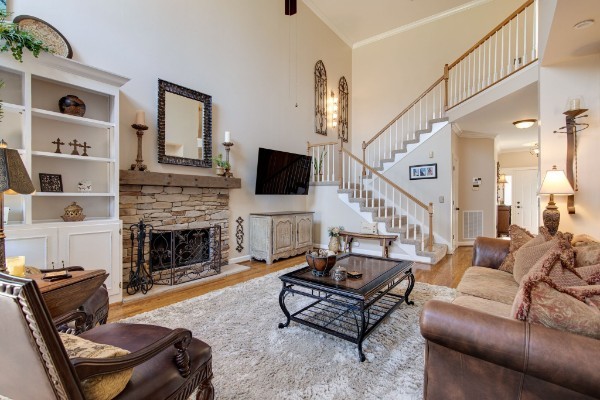 living room with ornamental molding, a towering ceiling, light hardwood / wood-style floors, and a fireplace