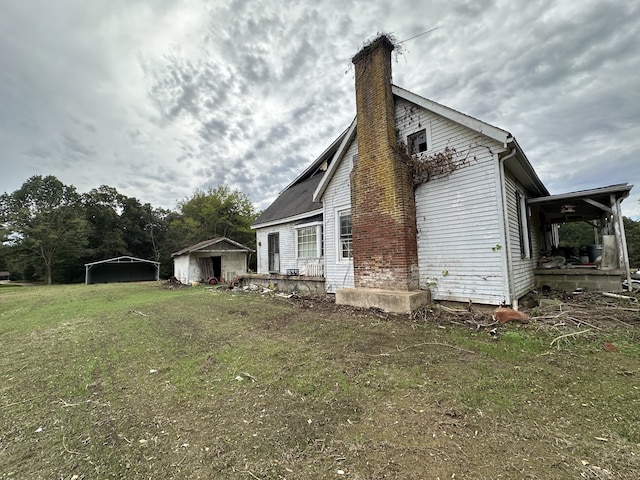 view of home's exterior with a lawn and a storage shed