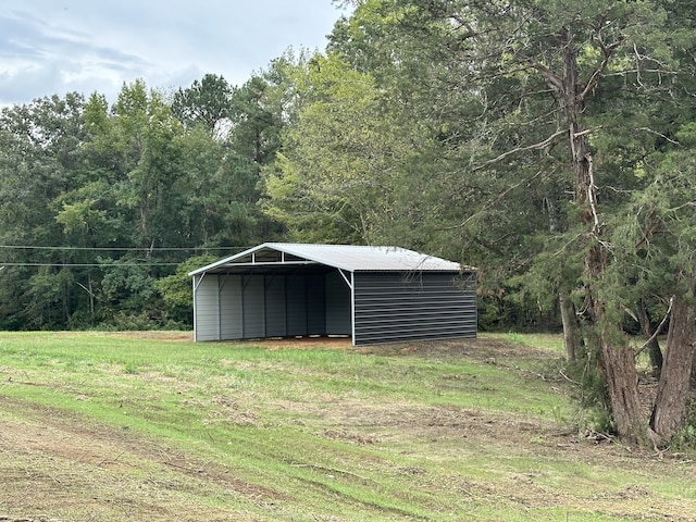 view of outdoor structure with a yard and a carport