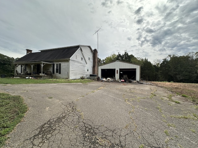 view of side of property featuring central AC, a garage, and an outdoor structure