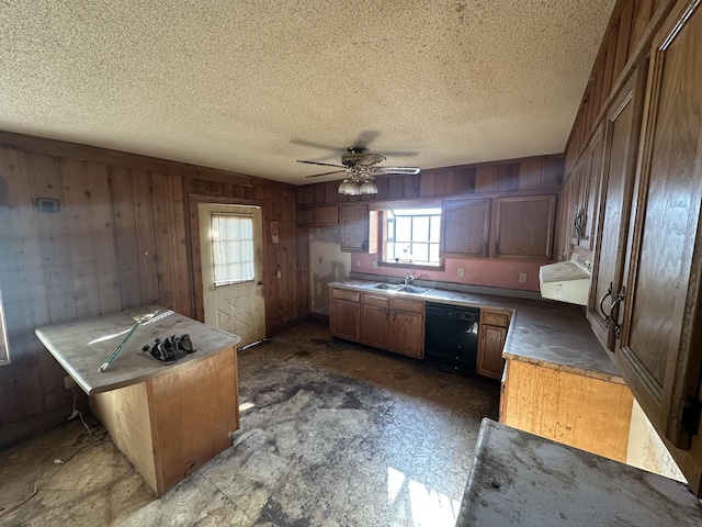 kitchen featuring dishwasher, ceiling fan, a textured ceiling, wooden walls, and sink