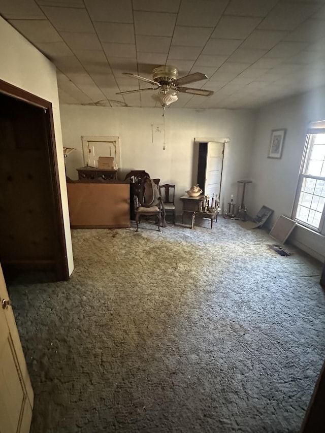 interior space featuring ceiling fan and carpet