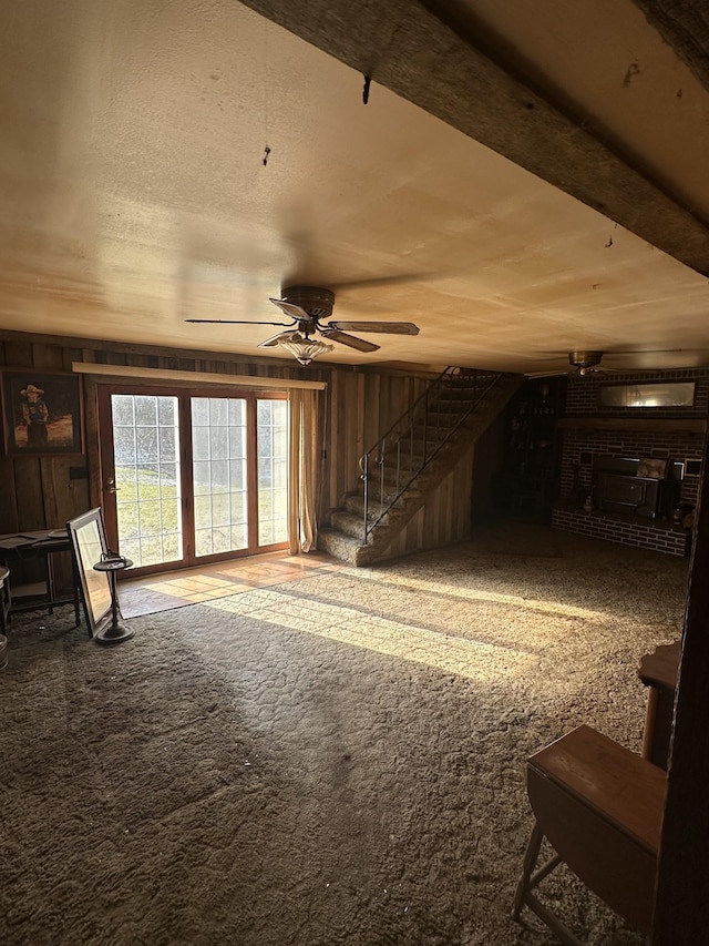 interior space featuring ceiling fan and wooden walls