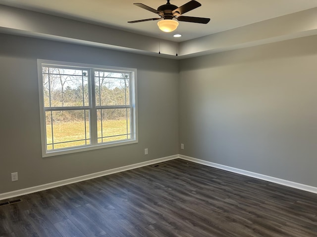 spare room featuring dark wood-type flooring and ceiling fan