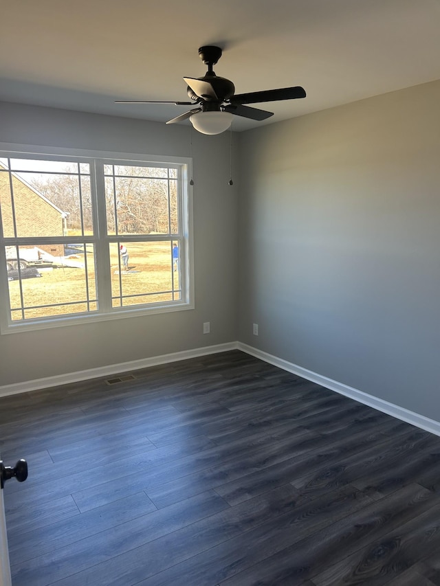 empty room with ceiling fan and dark hardwood / wood-style floors