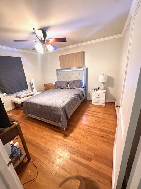 bedroom with light wood-type flooring, ceiling fan, and crown molding