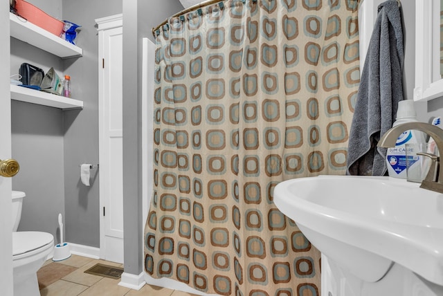 bathroom featuring tile patterned flooring, toilet, sink, and a shower with curtain