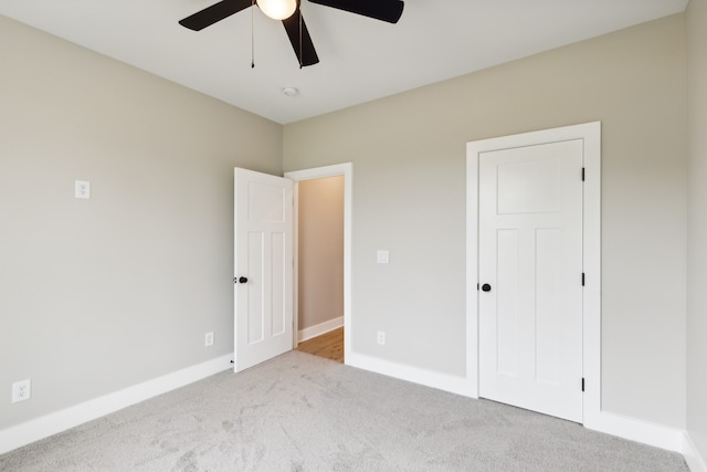 unfurnished bedroom featuring ceiling fan and light colored carpet