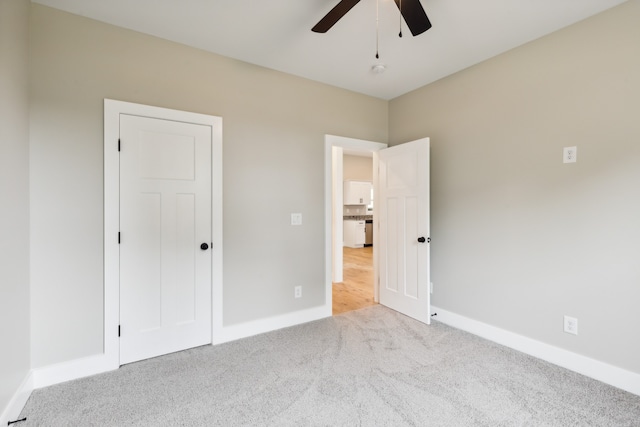 unfurnished bedroom with light carpet, a closet, and ceiling fan