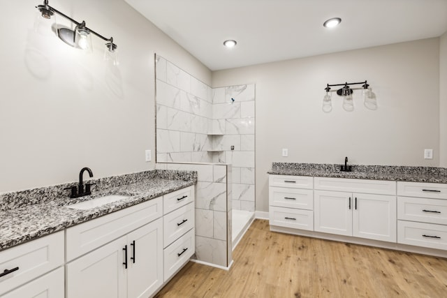 bathroom featuring vanity, hardwood / wood-style floors, and tiled shower