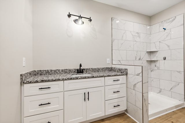 bathroom featuring vanity, hardwood / wood-style floors, and tiled shower