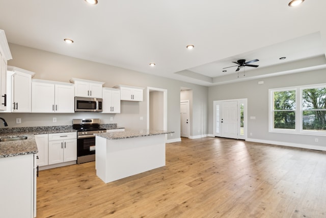 kitchen featuring dark stone countertops, sink, ceiling fan, and stainless steel appliances