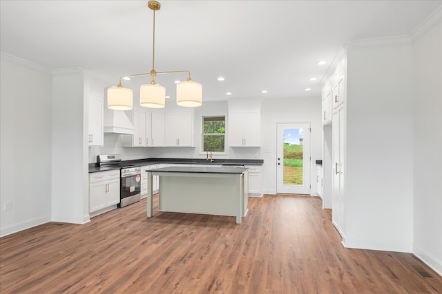 kitchen with white cabinets, hanging light fixtures, dark hardwood / wood-style flooring, and stainless steel range oven