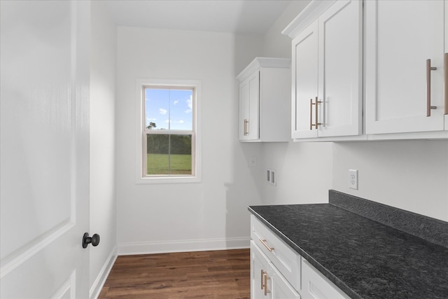 interior space featuring hookup for a washing machine, dark hardwood / wood-style floors, and cabinets