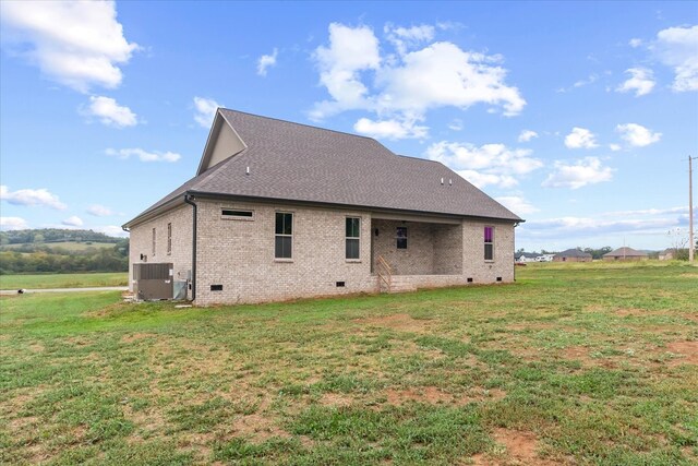 back of property with a lawn and central air condition unit