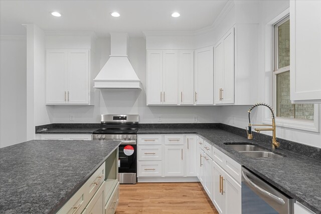 kitchen featuring white cabinets, sink, stainless steel appliances, and custom range hood