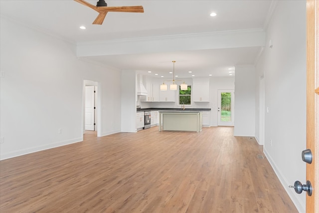 unfurnished living room with ornamental molding, light hardwood / wood-style floors, ceiling fan, and sink