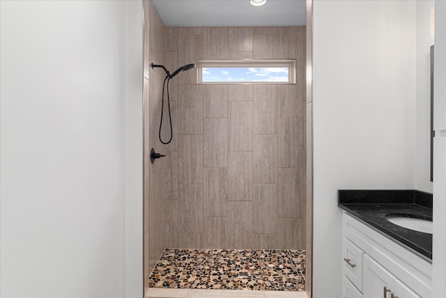 bathroom featuring a tile shower and vanity