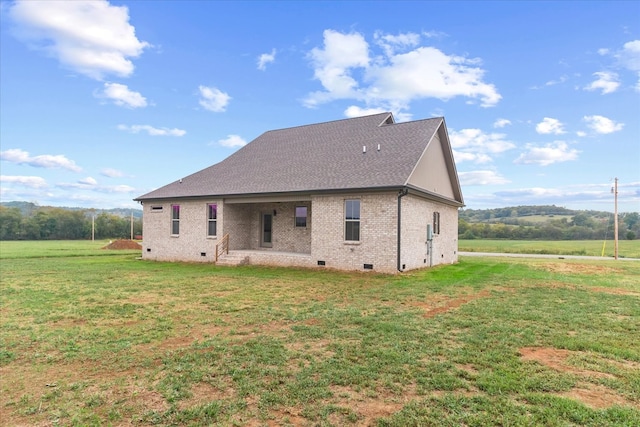 rear view of property featuring a lawn