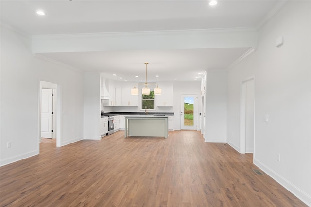 unfurnished living room featuring crown molding, sink, and light hardwood / wood-style flooring