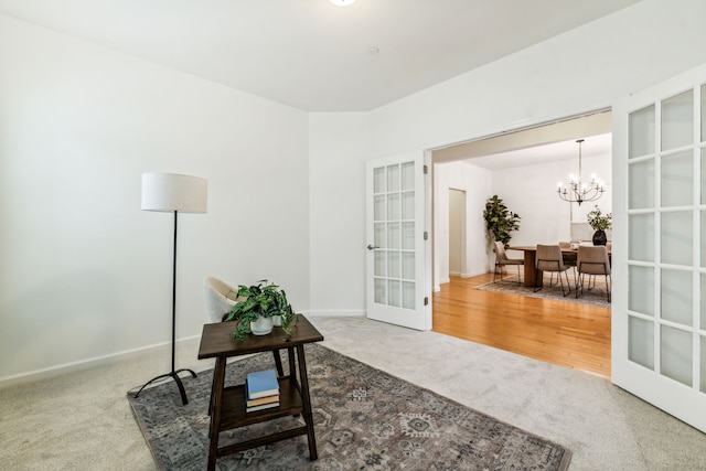 sitting room featuring carpet and a chandelier