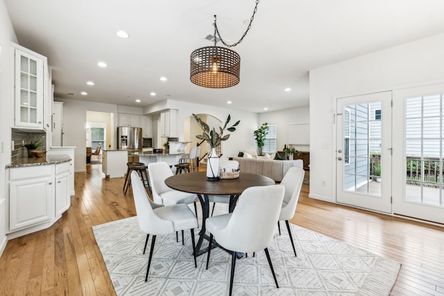 dining area with light wood-type flooring and a chandelier