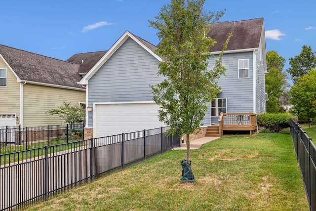 back of house with a garage, a wooden deck, and a lawn