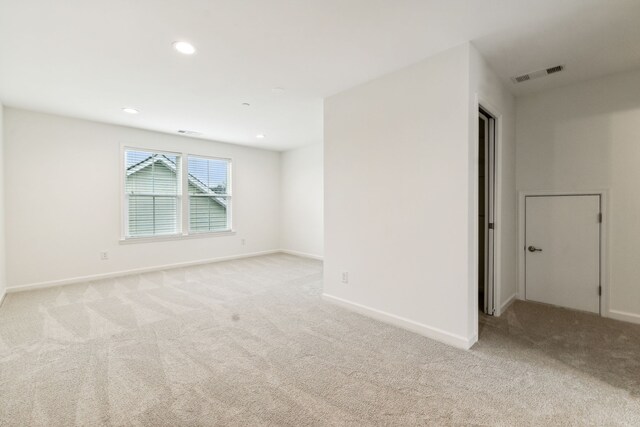 unfurnished room featuring light colored carpet