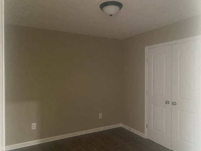 spare room featuring dark wood-type flooring