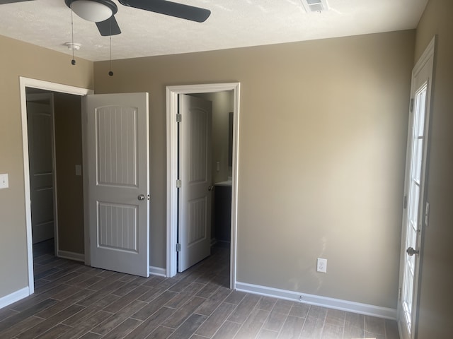 unfurnished room featuring a textured ceiling, ceiling fan, and dark hardwood / wood-style flooring