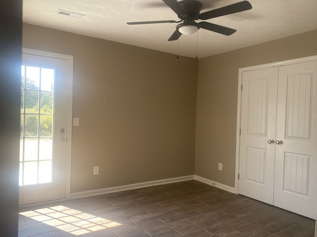 interior space featuring a textured ceiling, dark hardwood / wood-style flooring, ceiling fan, and a closet