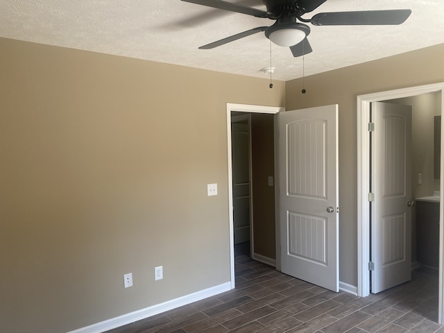 unfurnished bedroom with a textured ceiling, ceiling fan, and dark hardwood / wood-style flooring