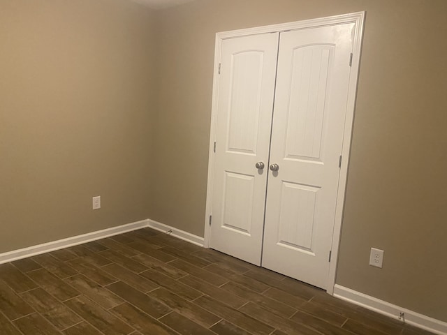 unfurnished bedroom featuring dark wood-type flooring and a closet