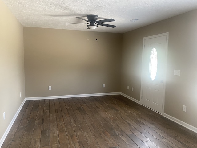 interior space with ceiling fan, a textured ceiling, and dark hardwood / wood-style floors