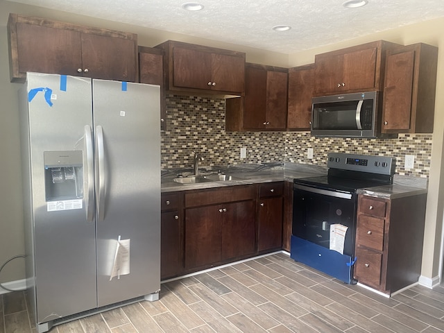 kitchen featuring dark brown cabinets, stainless steel appliances, and light hardwood / wood-style floors