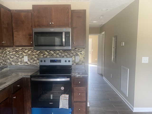 kitchen with appliances with stainless steel finishes, decorative backsplash, and dark brown cabinets