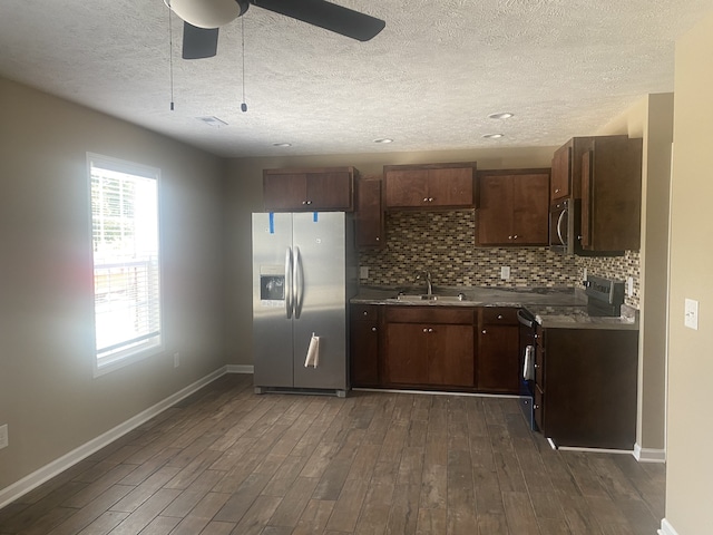 kitchen with a textured ceiling, dark wood-type flooring, sink, appliances with stainless steel finishes, and ceiling fan