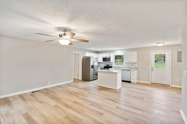 kitchen with white cabinetry, light hardwood / wood-style floors, appliances with stainless steel finishes, and ceiling fan