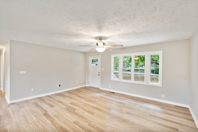 empty room featuring light hardwood / wood-style flooring, ceiling fan, and a textured ceiling