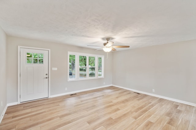 foyer entrance with a wealth of natural light, ceiling fan, and light wood-type flooring