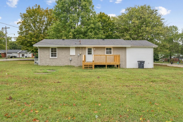 back of property with a deck and a lawn